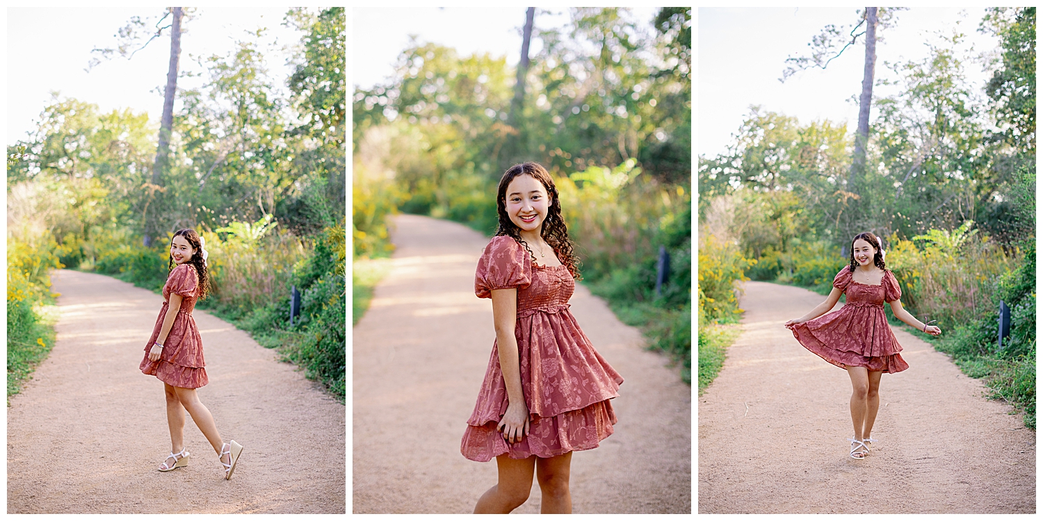 girl in mauve sundress twirling and laughing on pathway outside Houston Arboretum