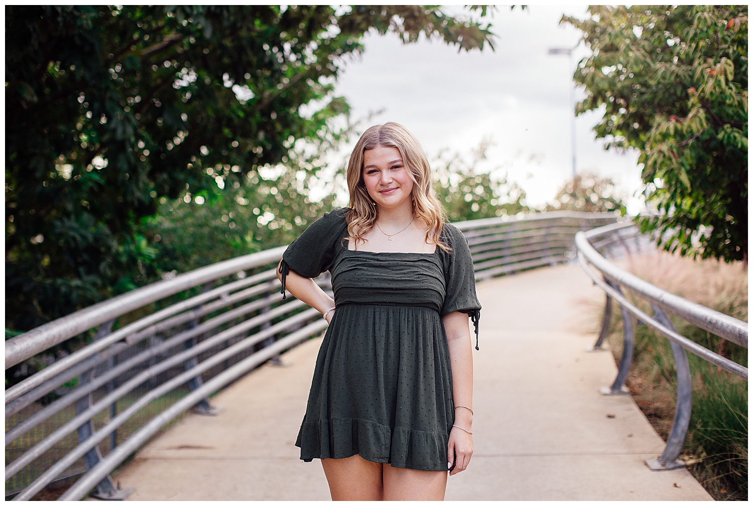 high school senior girl standing outside Sabine Park downtown Houston wearing green dress hand on hip