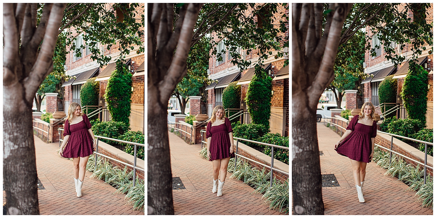 high school senior girl in maroon dress and white boots walking on sidewalk Houston skyline senior pictures downtown