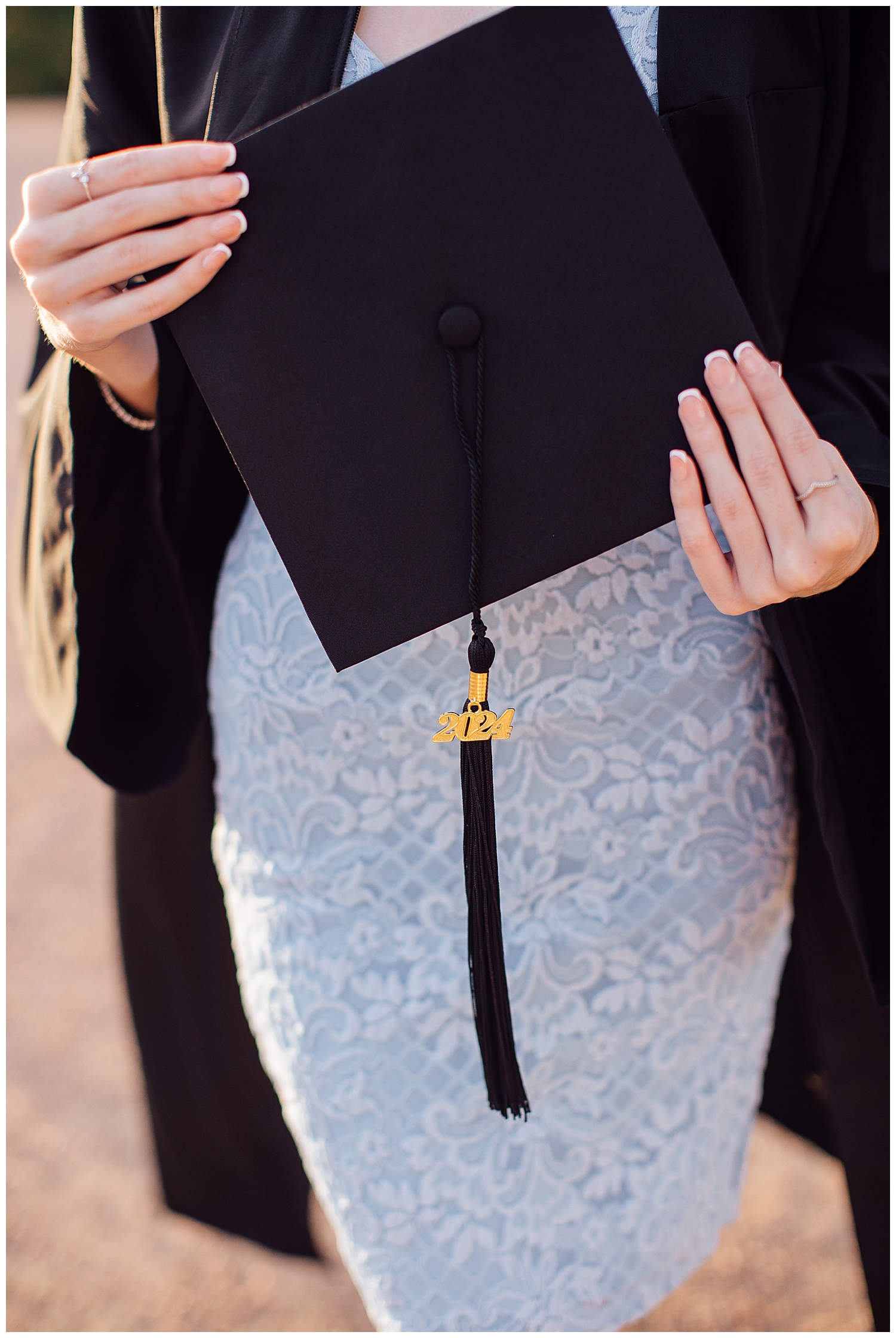 close up image of girls hands holding black graduation cap outdoor Houston senior pictures downtown