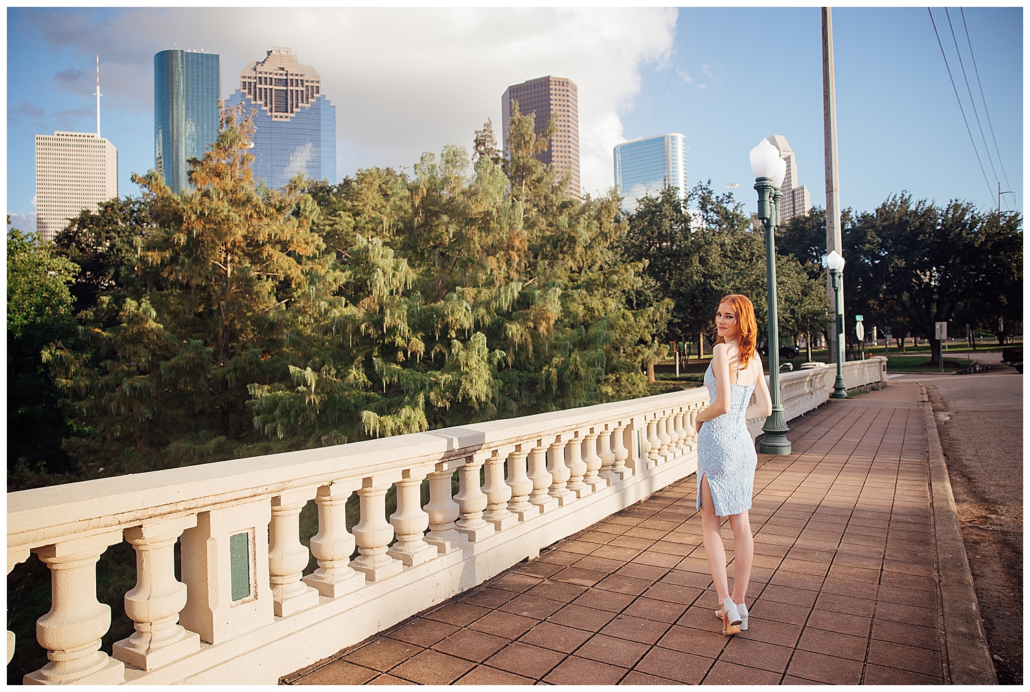 girl in baby blue sundress walking on Sabine street bridge in front of Houston skyline