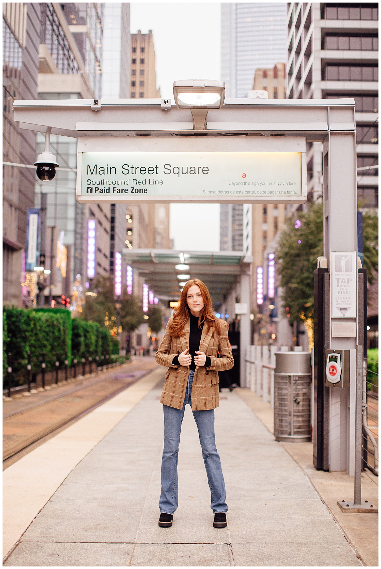 girl in jeans and brown tweed jacket standing under METRORail station Main Street