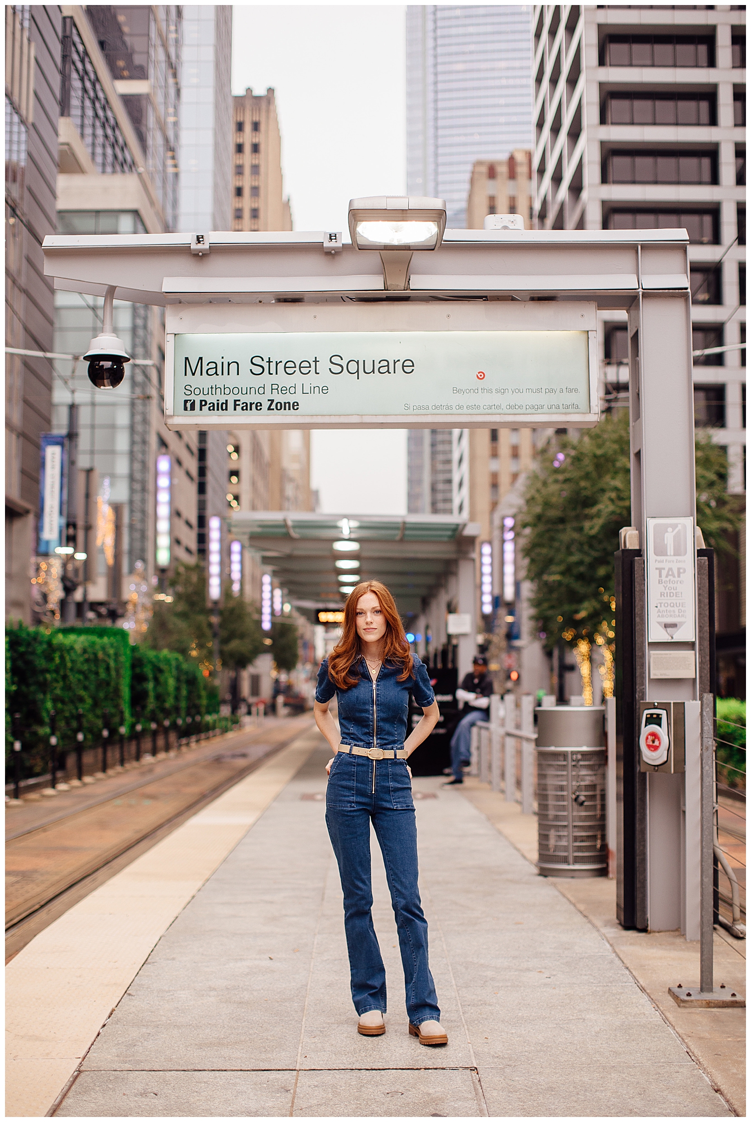 Downtown Houston Main Street Metro Rail with girl standing under sign in denim jumpsuit