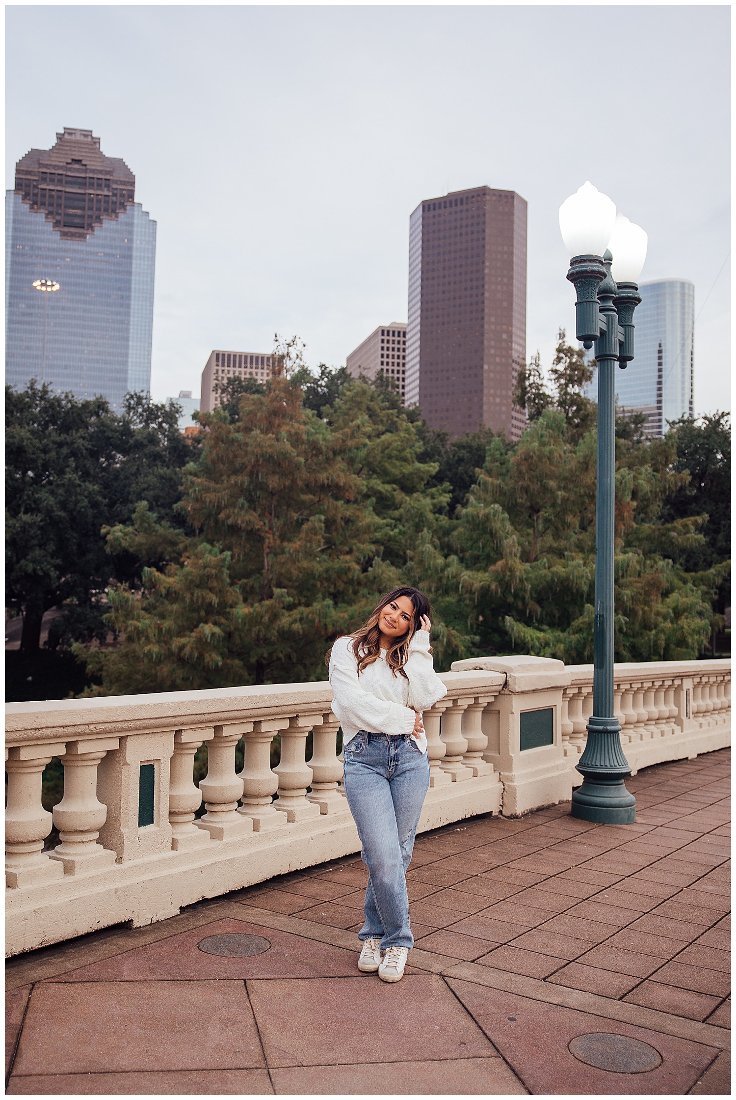 downtown Houston senior photography senior sessions with girl in jeans and white shirt standing sabine street bridge