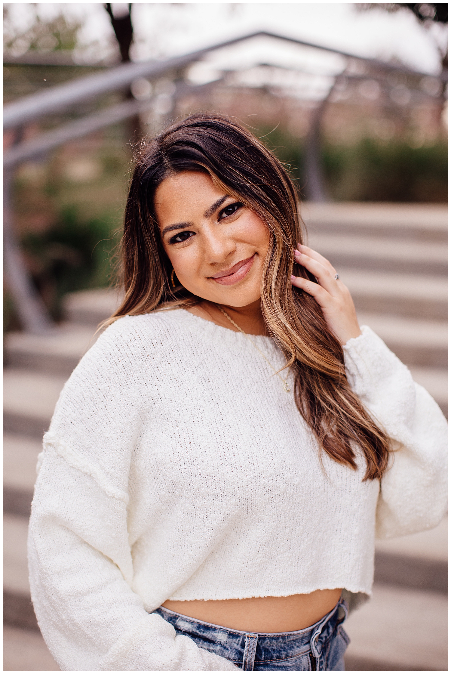 closeup image of high school girl in white sweater with hand in hair for Houston senior photography session Buffalo Bayou