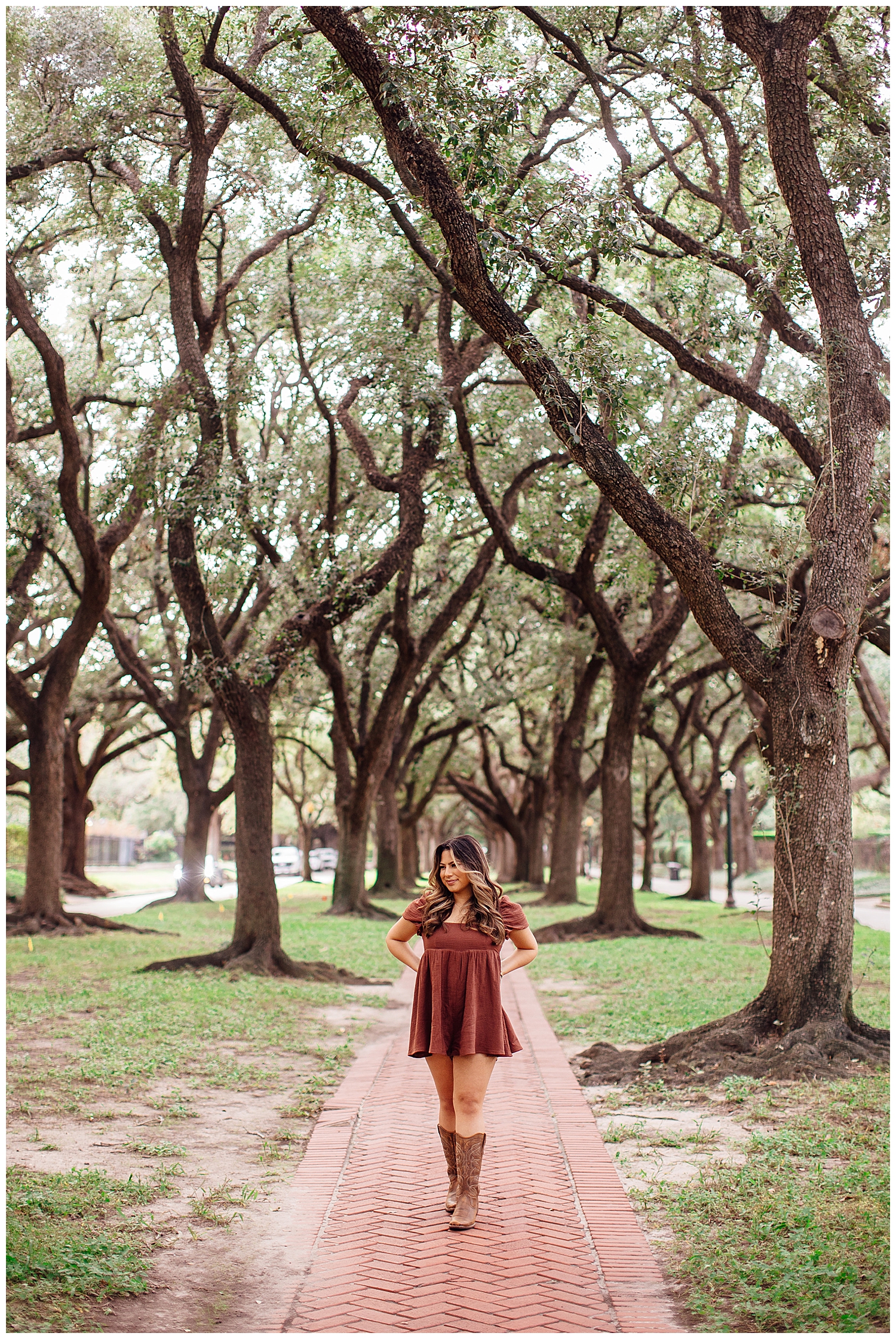 high school senior girl standing between North South tree line in rust sundress