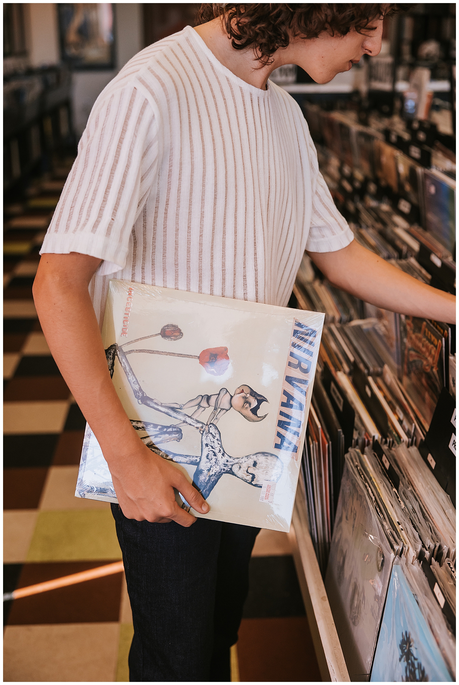 close up image of guy in white shirt holding record album