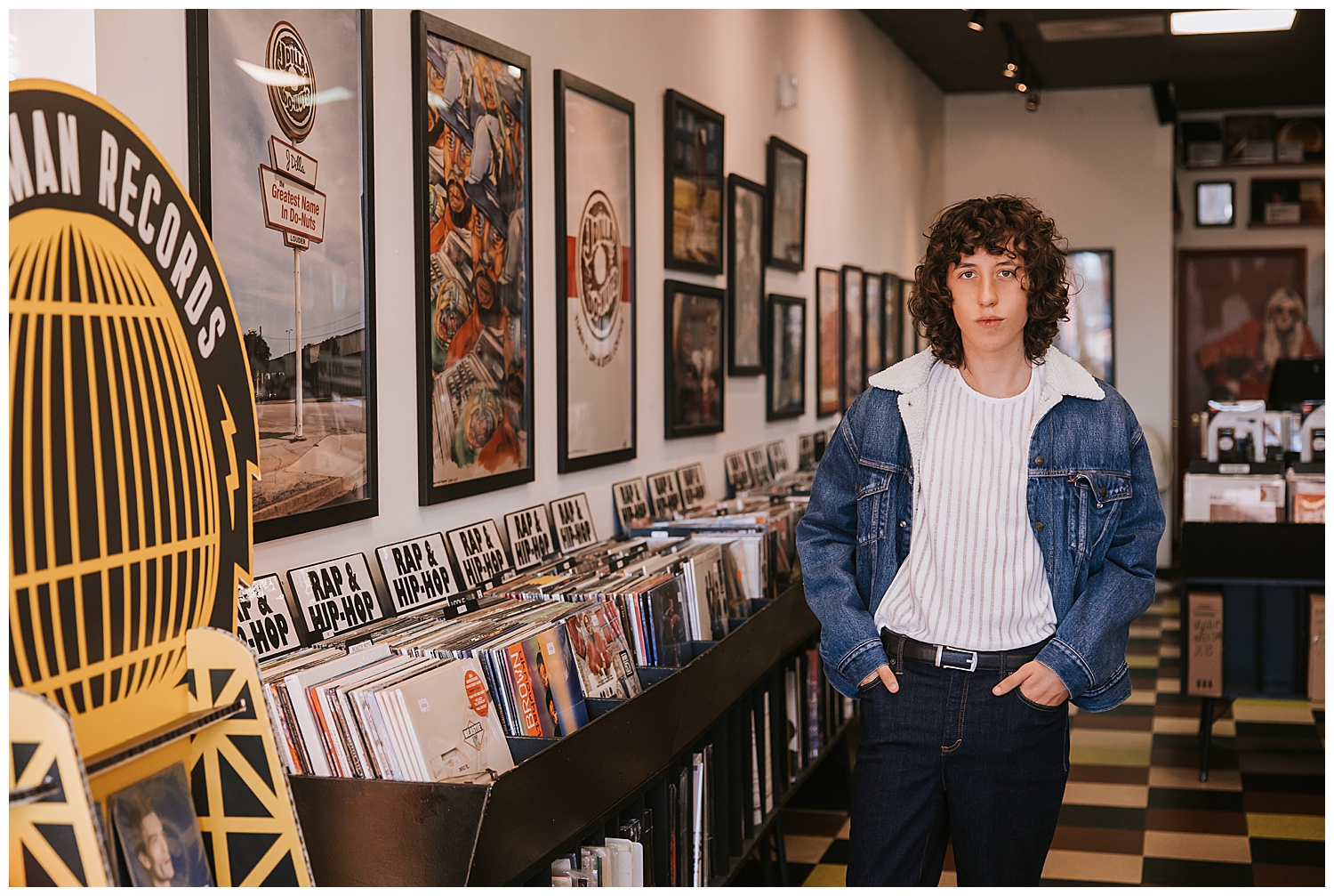 Cactus record store with guy in denim jacket standing in front of records with hands in pocket