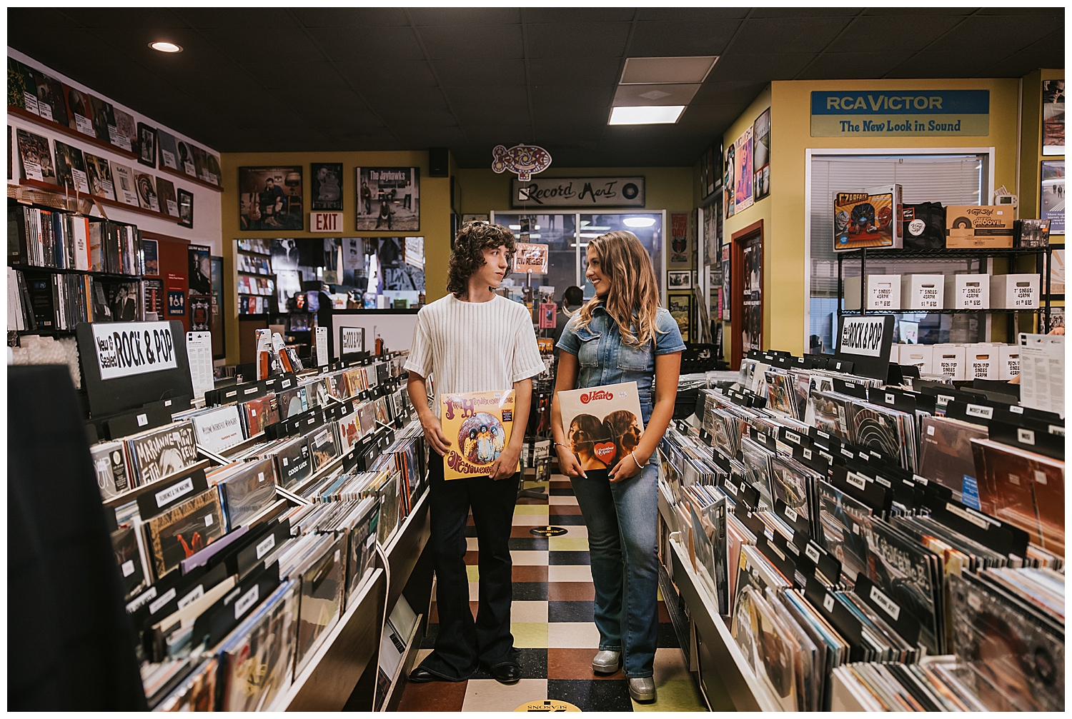 girl and guy twins holding record albums in aisle at Cactus Record store