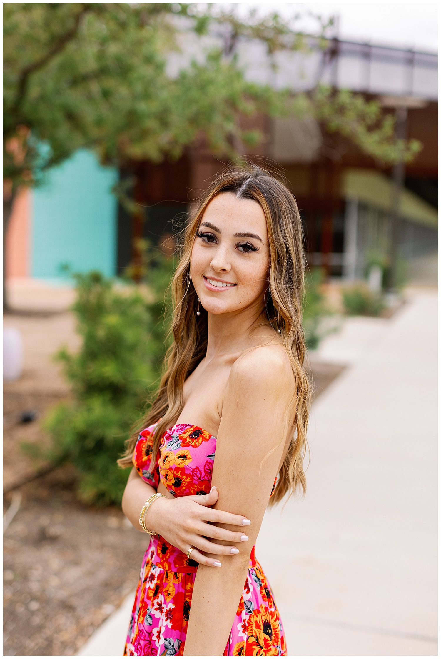 girl in red floral dress standing on sidewalk at Sugar and Cloth Color Wall Houston