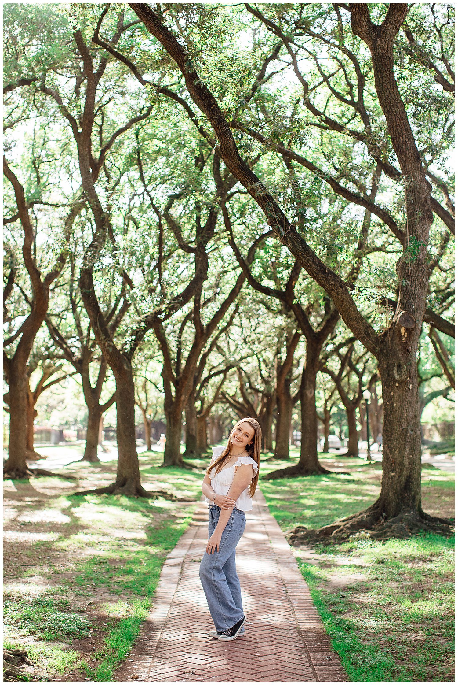 spring senior portraits Houston at North South Blvd with girl standing in jeans and white blouse