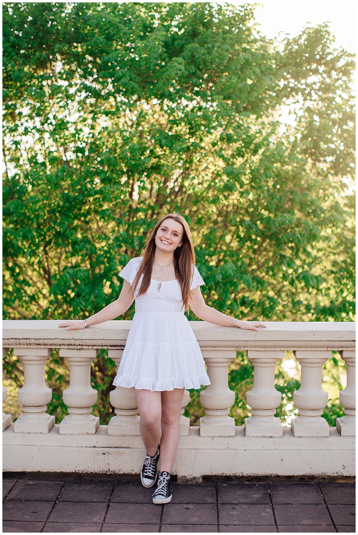 high school senior girl in white sundress standing on Sabine Street bridge Houston