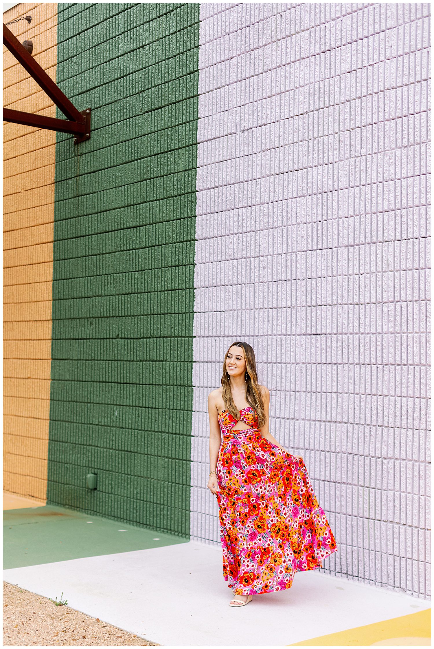 girl in red floral sundress walking in front of a multicolored wall outdoors Houston