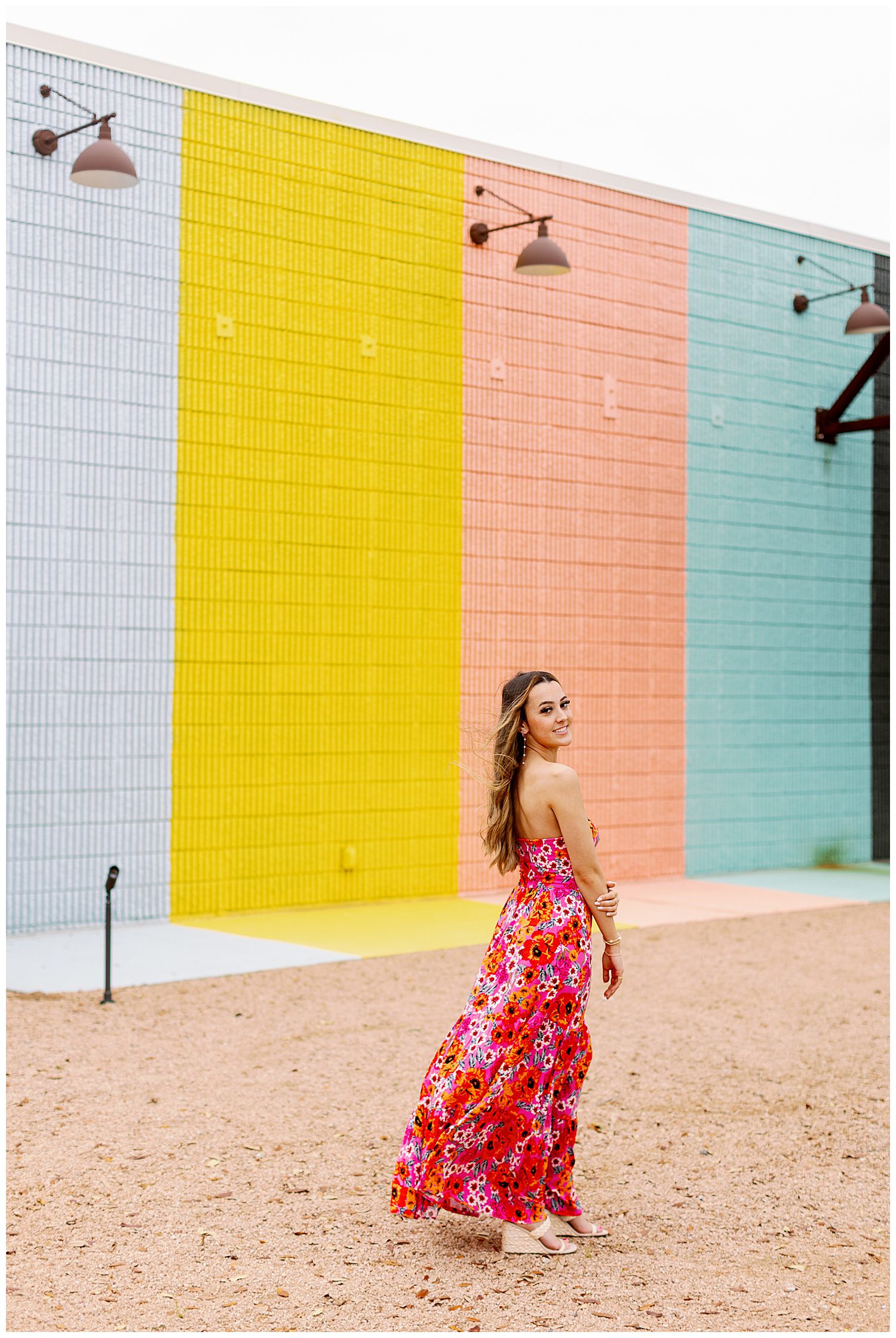 sugar and cloth color wall portraits of girl in red floral sundress walking and looking back over her shoulder in Houston