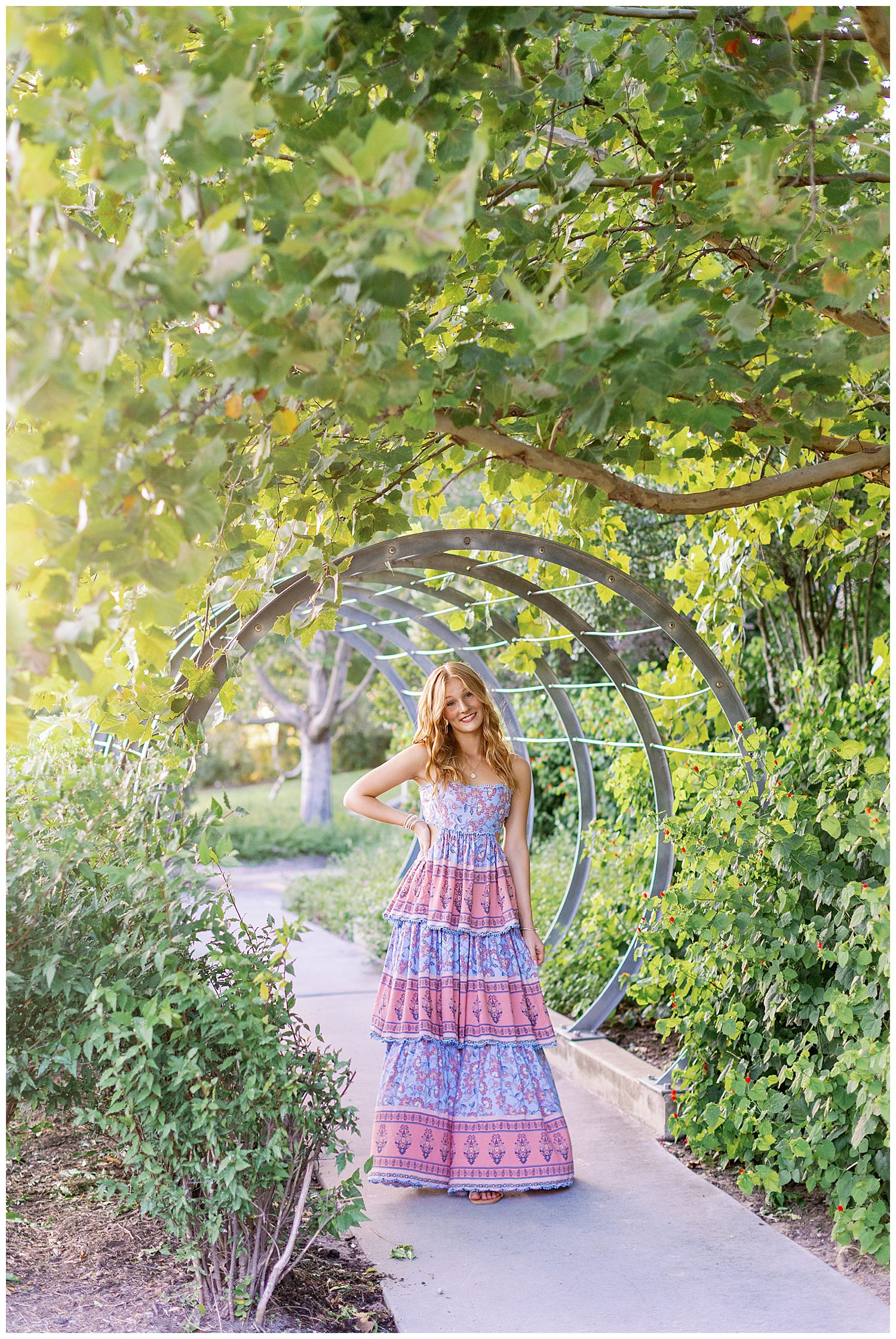 girl in sundress standing outdoors at Buffalo Bayou park in front of silver rings