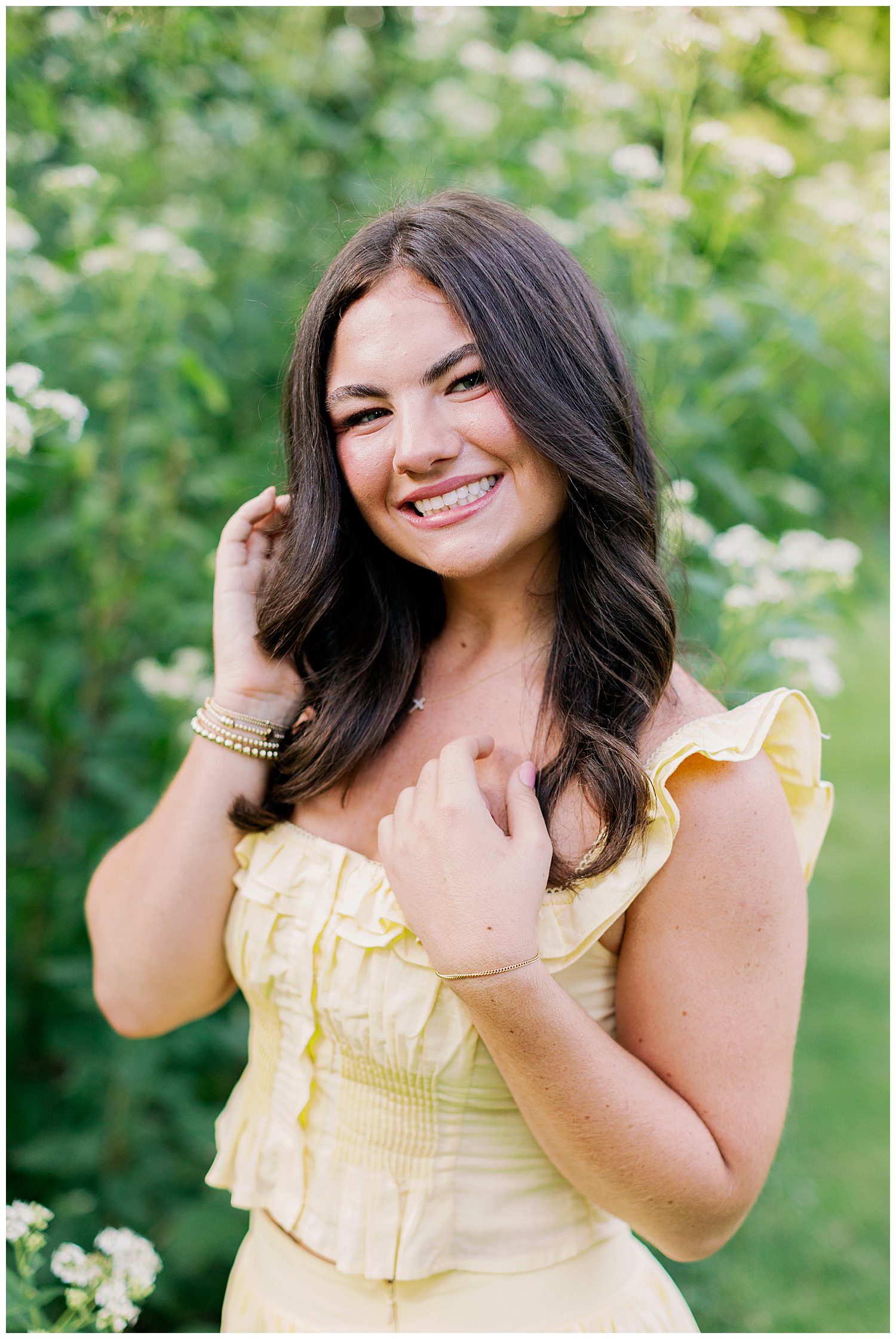 closeup image of girl in yellow dress with hands in hair standing outside Memorial Park Senior Photos